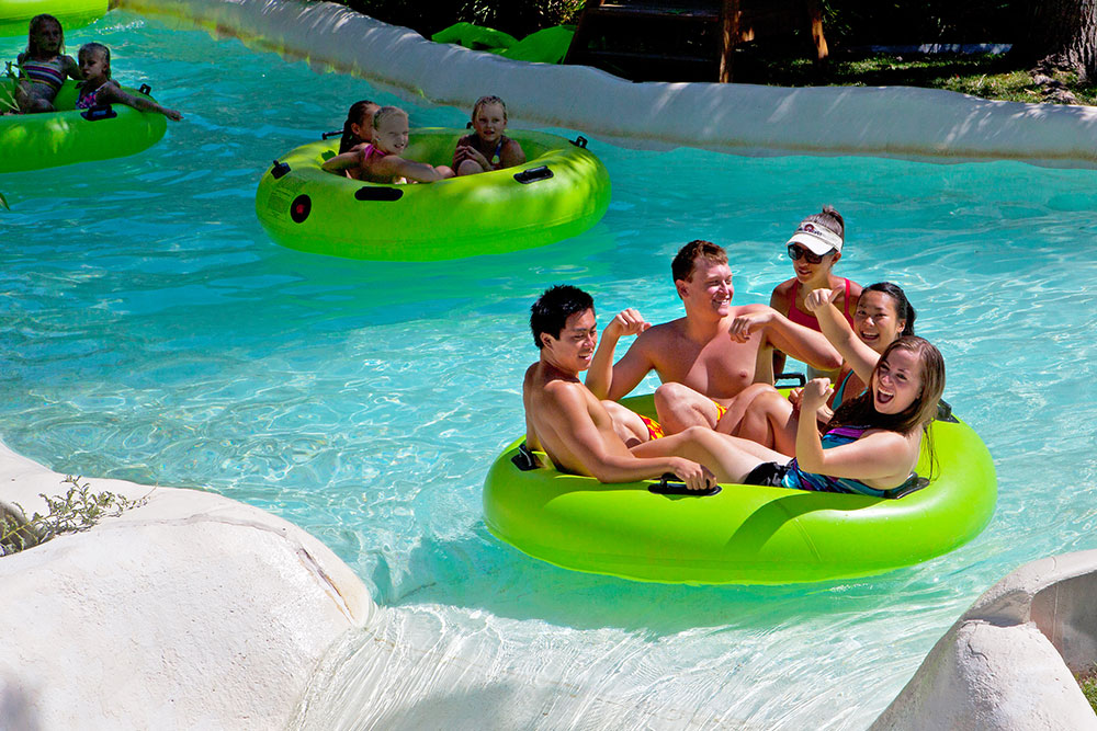 Kids and teenagers floating on water tubes at lazy river